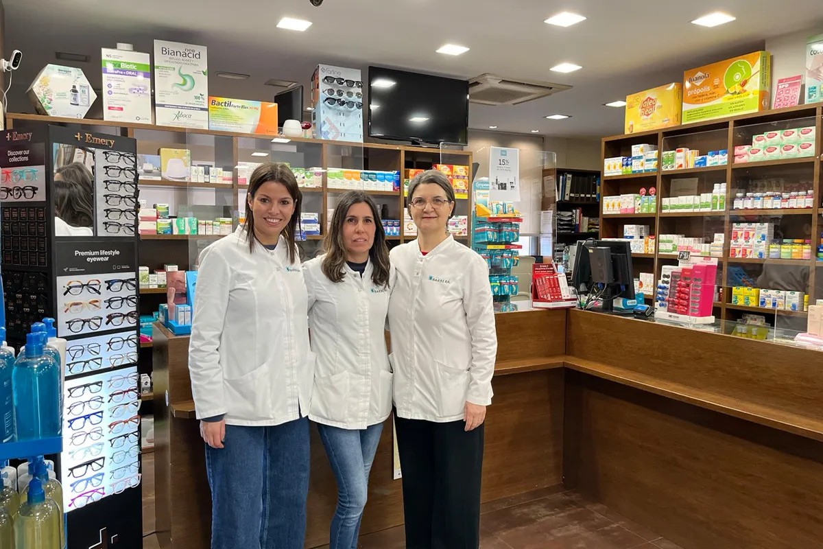 Equip de professionals de Farmàcia Barberà, associat de Sant Quirze Comerç, atenent en un espai amb productes farmacèutics.