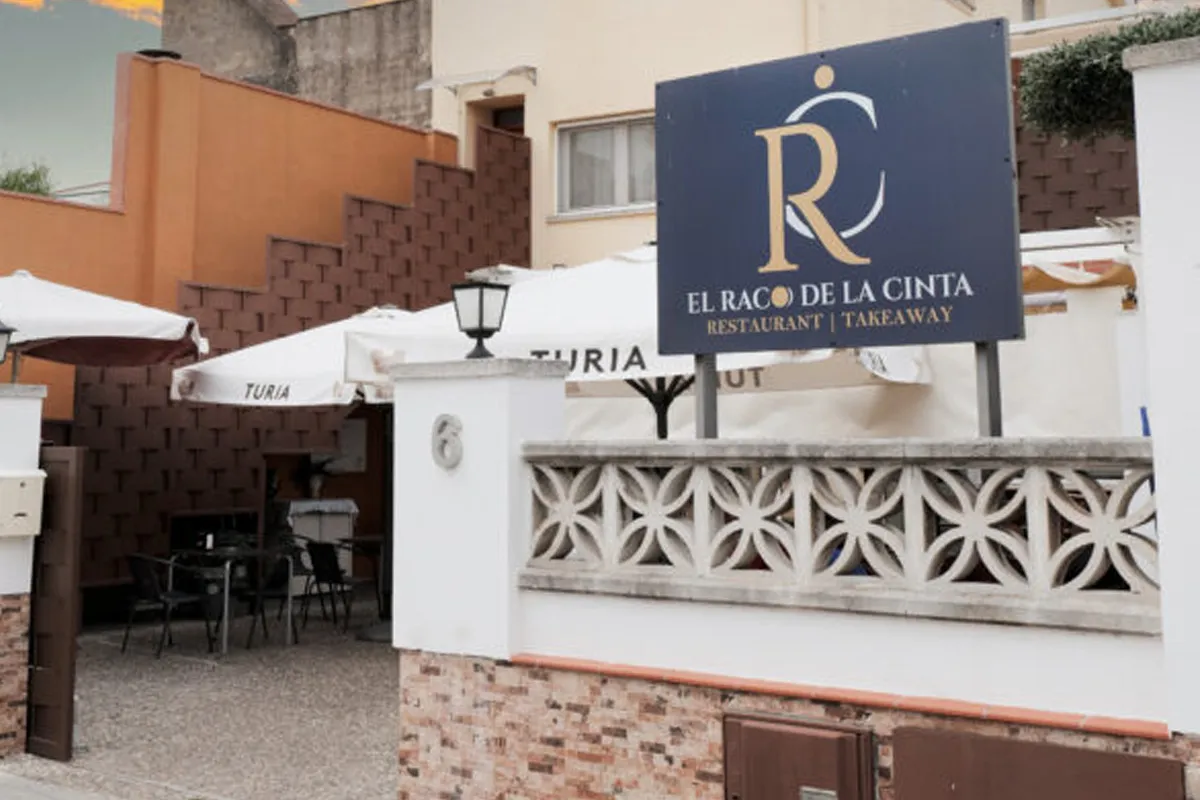 Façana del restaurant El Racó de la Cinta amb terrassa exterior i para-sols a Sant Quirze del Vallès
