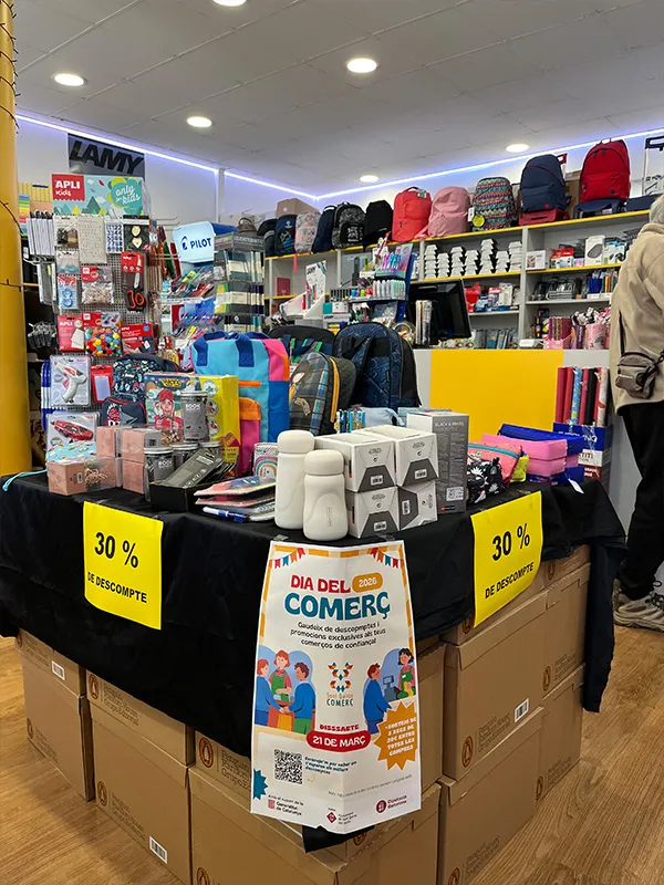 Taula amb material escolar i descomptes del 30% en una botiga durant el Dia del Comerç a Sant Quirze